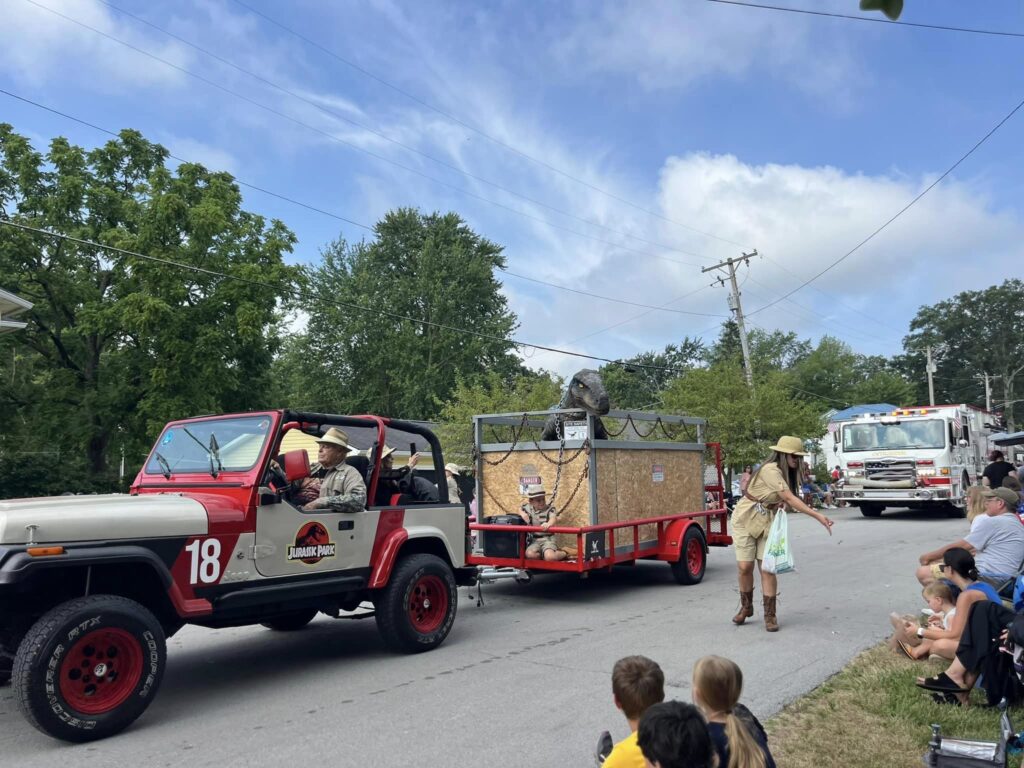 A Jurassic Park jeep towing a velociraptor in the 4th of July parade